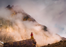 Kobieta na skale w zamglonych górach
