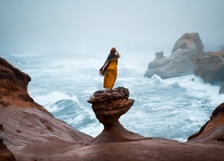 Kobieta na skale zapatrzona w morze