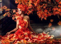 Kobieta ubrana w jesienne liście