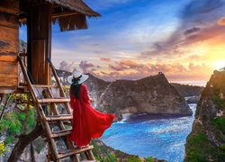 Kobieta w czerwonej sukni na tle gór wyspy Nusa Penidy