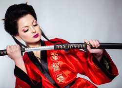 Kobieta w czerwonym kimono z mieczem samurajskim