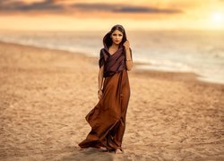 Kobieta w długiej sukience na plaży
