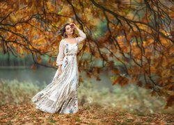 Kobieta w długiej sukni w jesiennym parku