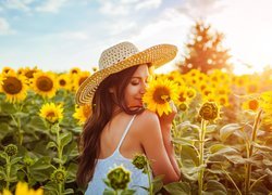 Kobieta w kapeluszu na polu słoneczników
