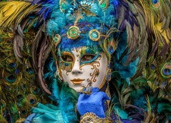 Kobieta w karnawałowej masce z pawimi piórami