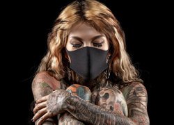 Kobieta w masce i tatuażach