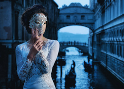 Kobieta w masce karnawałowej na tle Mostu Westchnień w Wenecji