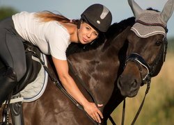 Kobieta w stroju jeździeckim na koniu
