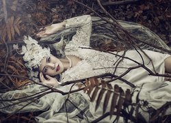 Kobieta w sukni ślubnej na opadłych liściach