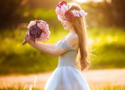 Kobieta w wianku na głowie z bukietem kwiatów w dłoniach