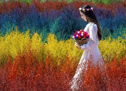 Kobieta w wianku wśród kolorowych roślin