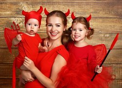 Kobieta z dziećmi w przebraniu na święto Halloween