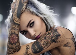 Kobieta z kolczykiem w nosie i z tatuażami na ciele