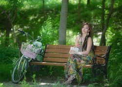Kobieta z książką na ławce w parku