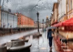 Kobieta z parasolem i pies na ulicy w deszczu