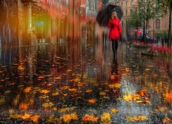 Kobieta z parasolem na ulicy pokrytej liśćmi w deszczu