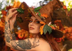 Kobieta z tatuażem w kapeluszu czarownicy