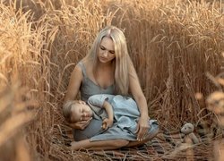 Kobieta ze śpiącą dziewczynką w zbożu