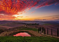 Kolorowe chmury zachodzącego słońca nad wzgórzami Toskanii