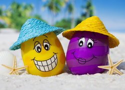 Kolorowe jajka w kapeluszach na plaży
