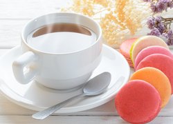 Kolorowe makaroniki przy filiżance herbaty
