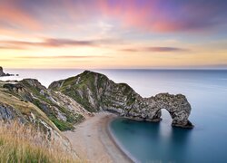 Kolorowe niebo nad łukiem wapiennym Durdle Door na Wybrzeżu Jurajskim w Anglii