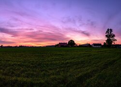 Kolorowe niebo wschodzącego słońca nad polami i domami