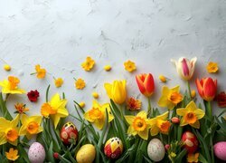 Kolorowe pisanki na żonkilach i tulipanach
