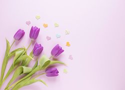 Kolorowe serduszka obok tulipanów
