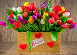 Kolorowe tulipany w pudełku z serduszkami ofiarowane na Dzień Kobiet