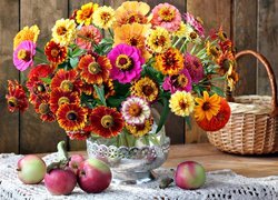 Kolorowy bukiet kwiatów i jabłka na stole