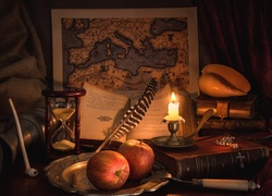 Kompozycja z klepsydrą, książkami, świecą oraz mapą