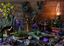 Kompozycja z kwiatów i różnych przedmiotów rozsypanych na stole