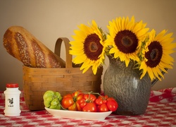 Kompozycja z pomidorami, chlebem i bukietem słoneczników w wazonie