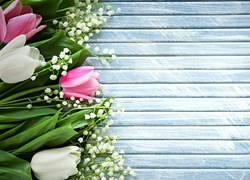 Konwalia majowa i tulipany ułożone na niebieskich deskach