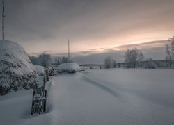 Kopki siana i drzewa w zimowej scenerii