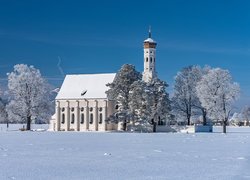 Kościół Eglise Saint Coloman wśród ośnieżonych drzew