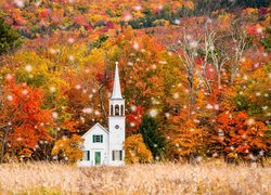Kościół na łące pod jesiennym lasem