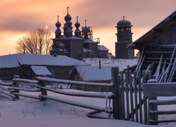 Kościół św Mikołaja i ośnieżone domy w rosyjskiej wsi Vorzogory
