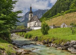 Kościół św Sebastiana w Ramsau bei Berchtesgaden nad rzeką na tle Alp
