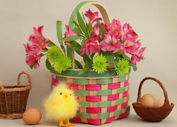 Koszyczek z jajkami obok kurczaczka i koszyka z kwiatami