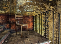 Krzesło przy schodach z balustradą w zniszczonym wnętrzu