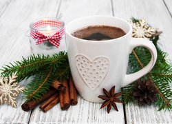 Kubek kawy między świątecznymi gałązkami