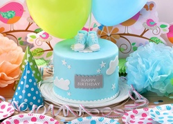 Kwiaty i balony obok urodzinowego tortu dla chłopczyka