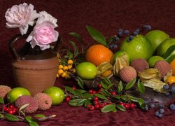 Kwiaty w wazoniku obok owoców