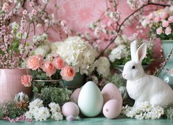 Kwiaty z gałązkami i królik obok pisanek