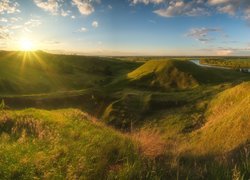 Łąka na wzgórzach w słonecznych promieniach