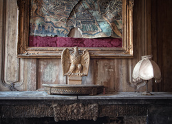 Lampa i rzeźba orła przy starej zniszczonej mapie w ramce
