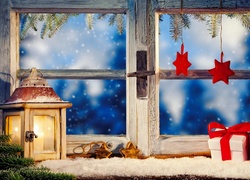 Lampion i prezenty na świątecznie przystrojonym oknie