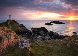 Latarnia morska Llanddwyn Lighthouse, Wyspa Anglesey, Walia, Morze, Skały, Wschód słońca, Chmury